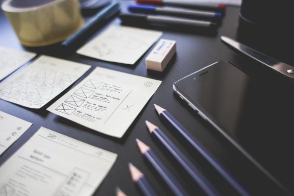 Desk with hand-drawn wireframes laid out neatly