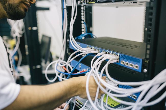 Man plugging cables into a server 