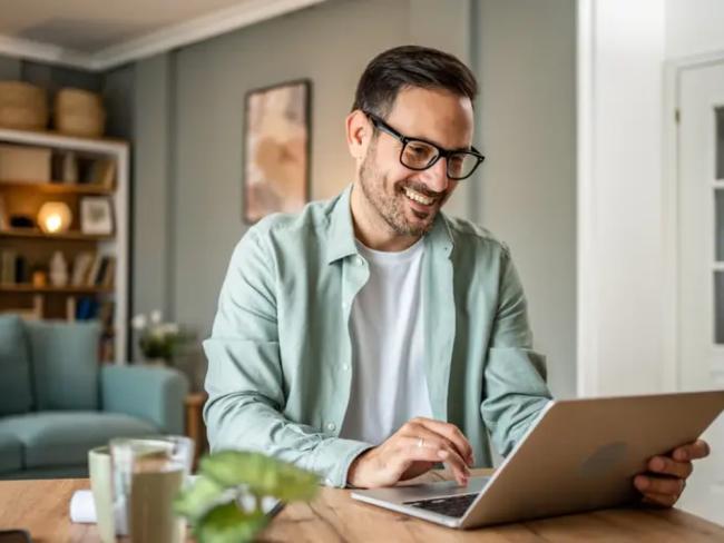 Man sitting at a table and working on a laptop